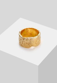 Anello in oro con superficie texturizzata e irregolare. Interno inciso con "Kuzzoí" e "925". Finitura interna liscia, design a banda larga.
