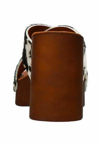 Bruine houten hak met een gekusschte zwart-witte bont bovenkant. Open teen ontwerp met een gladde afwerking. Achteraanzicht benadrukt de gebogen vorm.