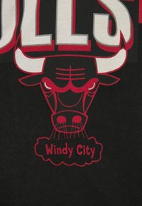 Zwarte stof met een grafisch ontwerp van een stierenkop met opvallende rode accenten en de tekst "Windy City" eronder.