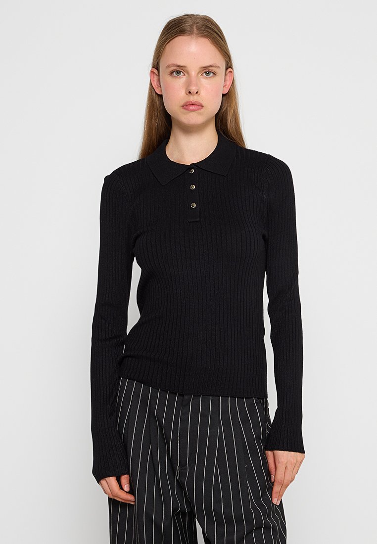 Maglietta polo nera a maniche lunghe con colletto, apertura a tre bottoni e design aderente. Il materiale sembra morbido ed elastico.