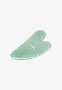 Grønn jade ansikts gua sha-verktøy med hjerteform, glatt overflate og glinsende finish, preget med "KIKO MILANO" i en dempet font.