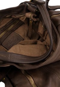 Braune Lederhandtasche mit beigem Innenfutter, mehreren Reißverschlussfächern und einem Markenlabel. Genähte Akzente und große Öffnung.
