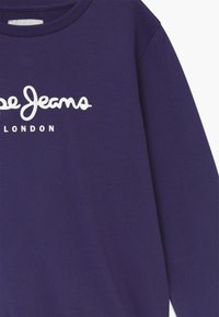 Fialový svetr s kulatým výstřihem, dlouhými rukávy a bílým logem "Pepe Jeans" s textem "LONDON" pod ním. Hladký povrch tkaniny.