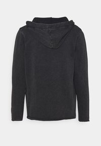 Svart långärmad hoodie med synliga sömmar, som visar baksidan och huven hängande ned.