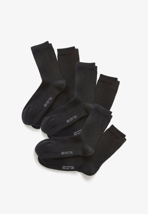 Sechs Paar schwarze, knöchellange Socken, überlappend angeordnet, jeweils mit dem Schriftzug "BIO COTTON" in weißer Schrift auf der Sohle beschriftet.