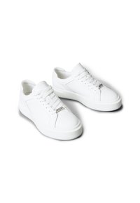 Białe sneakersy wykonane z gładkiego materiału, z zaokrąglonym noskiem, sznurowaniem oraz podwyższoną podeszwą z subtelnymi detalami.