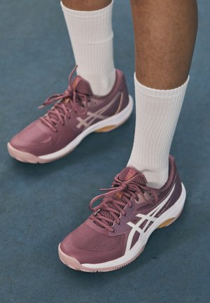 Paarse sport schoenen met witte accenten, van mesh materiaal, met een gestructureerde oppervlakte en veters. Draagt met witte geribde crewsokken.