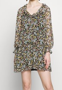 Květinové šaty s černým pozadím, s volánkovým výstřihem a rukávy. Vyrobené z lehké, průhledné látky s vrstveným lemem.