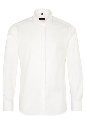 Chemise blanche à manches longues en coton doux avec un col pointu et un devant à boutons. Elle possède des poignets avec fermetures à boutons et un ourlet arrondi.