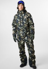 Hiihtopuku, jossa on vihreän ja mustan sävyisessä jäämurtajakuosissa, valmistettu kestävästä materiaalista. Varustettu vetoketjukiinnityksellä, taskuilla, hanskoilla ja suojalaseilla.