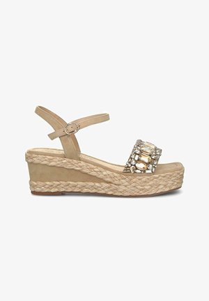 Sandalias de cuña beige con suela de yute trenzado, una tira de ante y una hebilla decorativa de strass en el dedo del pie. Incluye correa ajustable para el tobillo.