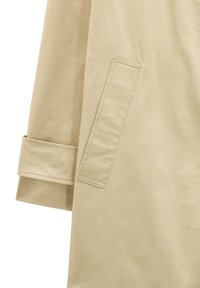 Beżowy płaszcz trench z detalami, takimi jak wszywana kieszeń, podwinięty mankiet i gładka faktura, podkreślający minimalistyczny design z czystymi liniami.