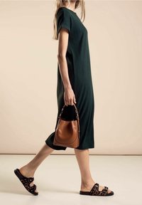 Vihreä ribattupintainen midi-mekko lyhyillä hihoilla, yhdistettynä mustiin leopardi-kuosisii liukumekkoihin ja ruskeaan ämpärilaukkuun. Yksinkertainen ja moderneja muotoilu.