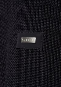 Czarny sweter dzianinowy o fakturowanym wykończeniu. Posiada prostokątną czarną łatkę z wypukłym srebrnym logo marki "bugatti".