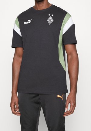 Schwarzes T-Shirt mit kurzen Ärmeln und grünen sowie weißen Akzenten. Mit Puma-Logo und Team-Emblem auf der Brust. Weiches Baumwollmaterial.