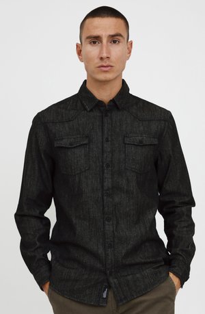 Black button-up shirt with a textured fabric, featuring two chest pockets and a standard collar. Long sleeves with buttoned cuffs.