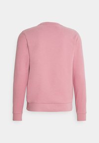 Sweat-shirt rose à manches longues vu de dos, avec des poignets et un ourlet côtelés, sur fond blanc.