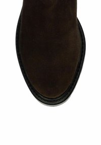 Bottines en daim marron avec un bout arrondi, semelle en cuir et couture noire contrastante. Surface texturée visible. Design minimaliste.