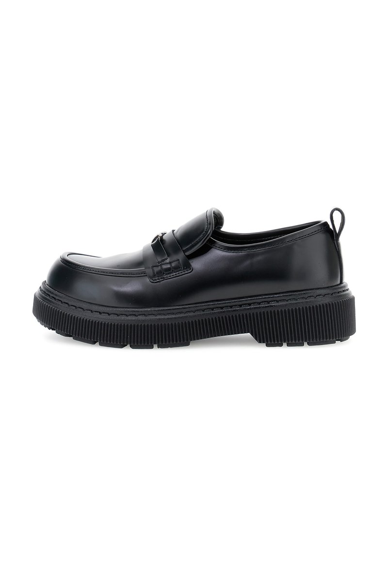 Mocasín de cuero negro con suela gruesa y estriada, detalle de cinta y asa en el talón, mostrado en perfil izquierdo sobre fondo blanco.