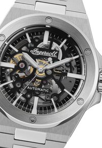 Roestvrijstalen automatische horloge met een zwart skeletdial, zilveren wijzers en opvallende Ingersoll-branding. Heeft gedurfde uurmarkeringen.