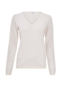 Jasno beżowy sweter z dekoltem w serek i długimi rękawami. Korpus jest gładko dziany, rękawy mają teksturowany wzór ażurowy oraz ściągacze.