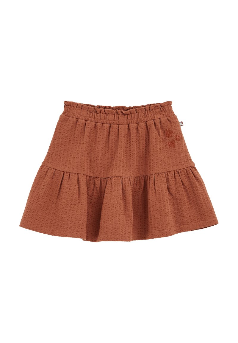 Jupe en couches de couleur rouille avec une taille élastique, présentant un motif de tissu texturé et un petit détail brodé sur le côté.