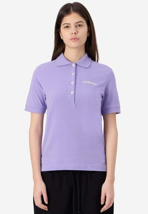 Polo shirt corto in lilla realizzato in cotone, con una chiusura a tre bottoni. Presenta un logo discreto sul petto e un colletto classico.