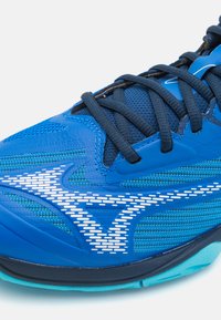 Pantofii sport de culoare albastră, cu un superior texturat, panouri din plasă și accente reflectorizante albe. Șireturile negre și o talpă din cauciuc completează designul.