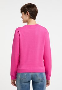 Pulover tricotat de culoare roz fuchsia, cu mâneci lungi și manșete și tiv cu model răsucit. Spatele are o textură netedă și un guler rotund.