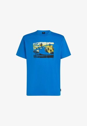 Blå bomulds-T-shirt med et grafisk design af en strandscene med palmer og bølger i gul og sort. Rund hals og korte ærmer.