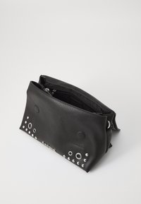 Pochette en cuir noir, ornée de clous et d'accents ronds. Fermeture éclaire sur le dessus avec un intérieur doublé pour l'organisation.