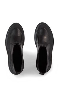 Botas de tobillo de cuero negro con paneles laterales elásticos, puntera redondeada, suela de goma y tirador. Acabado suave con detalles de costura.