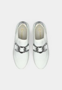 Λευκά πλεκτά αθλητικά παπούτσια με λείο ασημί λουράκι στη μέση του ποδιού και υφή στη μύτη. Το μέγεθος αναγράφεται ως 37.