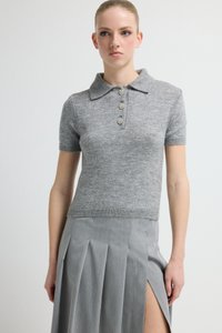 Grijs gebreid poloshirt met korte mouwen, drie decoratieve knopen bij de hals, gecombineerd met een grijze geplooide rok met een zijsplit.