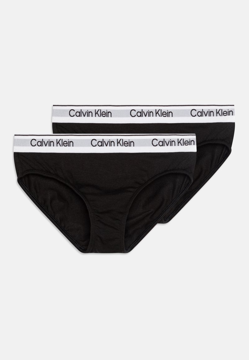 Čierne bavlnené slipy s bielym elastickým pásom s logom "Calvin Klein". Zobrazené sú dva kusy, ktoré ukazujú mäkkú tkaninu a bezšvový dizajn.