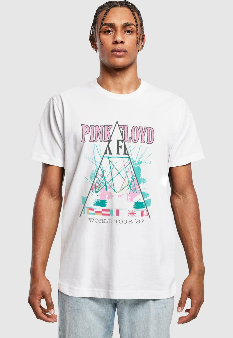 T-shirt en coton blanc avec un graphisme Pink Floyd en rose, turquoise et bleu, présentant des motifs triangulaires et le texte "TOUR MONDIAL '87".