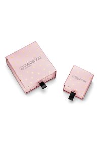 Due scatole di cartone rosa, una più grande e una più piccola, con motivi a cuori dorati e linguette nere, caratterizzate dal logo "GLANZSTÜCKE MÜNCHEN."
