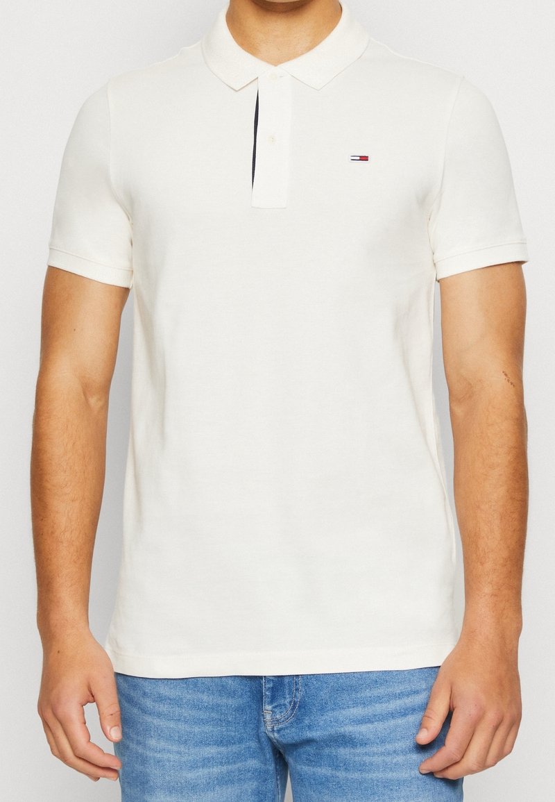 Camisa polo blanca de manga corta, con cuello de botones y un pequeño logo en el lado izquierdo del pecho. Fabricada en suave tela de algodón.