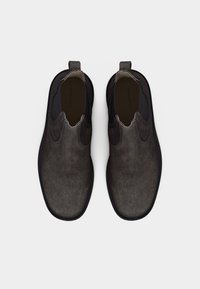 Ζεύγος σκούρων γκρι τσόκερ μποτών από σουέντ με μαύρα ελαστικά πλαϊνά πάνελ και θηλιές τράβηγματος, σε θέαση από πάνω πάνω σε άσπρο φόντο.