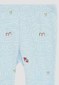Lichtblauwe leggings met een spiraalpatroon en illustraties van een kikker, een krab met een hart en kleine hartaccenten.