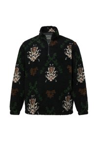 Sudadera de forro polar negra con cuello alto, que presenta intrincados patrones florales y de enredaderas en marrón, verde y crema. Cierre de media cremallera.