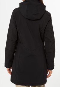 Svart vattentät rock med huva, som har en figursydd midja, långa ärmar och sömdetaljer på baksidan för en strukturerad design.