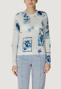 Maglione bianco con stampa floreale e grafica blu, polsini e orlo a costine, scollatura rotonda, con etichette con design e motivi.