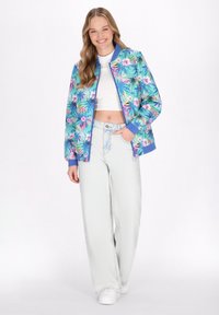 Bomberka z tropikalnym kwiatowym wzorem w odcieniach zieleni, niebieskiego i różowego, z zapięciem na zamek, ściągaczami na rękawach oraz białym topem w stylu crop pod spodem.