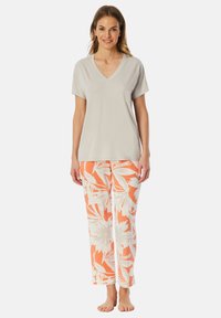 Ljusgrå V-ringad t-shirt i kombination med orange och vita blommönstrade pyjamasbyxor. Mjuk tygkvalitet, avslappnad passform och rak ben-design.
