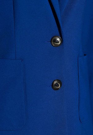 Blauer Blazer mit glatter Textur, zwei schwarzen Knöpfen und einer Seitentasche. Der Stoff wirkt maßgeschneidert und strukturiert für eine figurbetonte Passform.