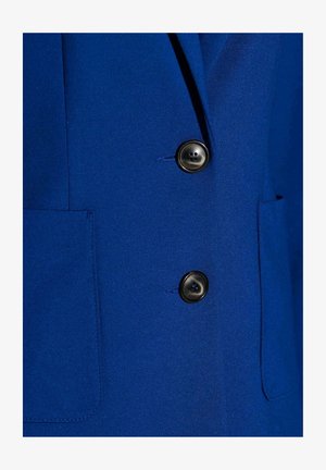 Blauer Blazer mit glatter Textur, zwei schwarzen Knöpfen und einer Seitentasche. Der Stoff wirkt maßgeschneidert und strukturiert für eine figurbetonte Passform.