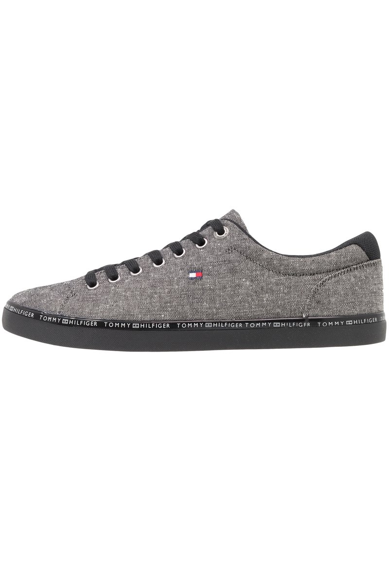 Sneaker grigio in tela con suola in gomma nera, dotato di occhielli argentati, lacci neri e striscia con logo lungo la suola.