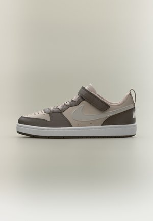 Sneaker Nike low-top beige e marrone con suola bianca, allacciatura frontale, cinturino regolabile e linguetta sul tallone.