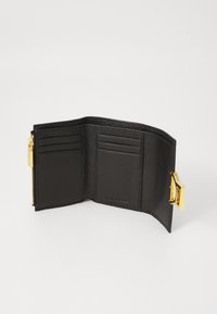 Portafoglio in pelle nera con molte tasche per carte, hardware dorato e chiusura con zip. Finitura testurizzata con una forma rettangolare compatta.